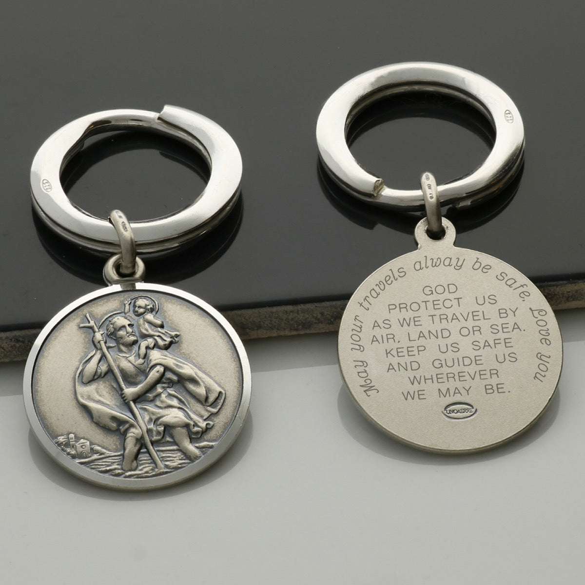 Back view of Antique Finish Sterling Silver 24mm St Christopher Keyring With Travellers Prayer and personalised engraving around the back border in baby script font